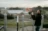 shallow focus photography of man taking a photo near fences